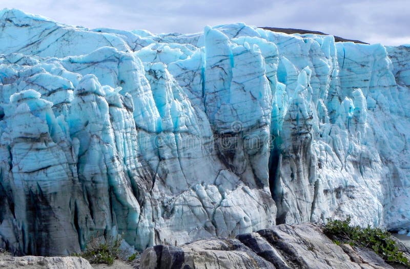 GROENLANDIA glacier with dramatic blue ice formations and crevasses. Symbol of Arctic melting ice, climate change, global warming and fragile polar environment in GROENLANDIA and the Arctic region. World climate change stock images, royalty-free photos and pictures