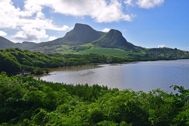 Green landscape with coastal mangroves water and Lion Mountain nearby Mahebourg, Mauritius. There is a memorial platform on the far left of the picture. Green landscape with coastal mangroves water and Lion Mountain nearby Mahebourg, Mauritius. There is a memorial platform on the far left of the picture.