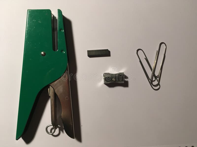 Groene nietmachine met het pennemes van de puntpaperclip stock foto Groene nietmachine met het pennemes van de puntpaperclip stock foto