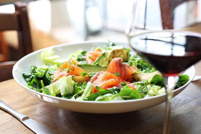 Groene salade met spinazie en raketbladeren met zalm, avocado en peer stock afbeelding Groene salade met spinazie en raketbladeren met zalm, avocado en peer stock afbeelding