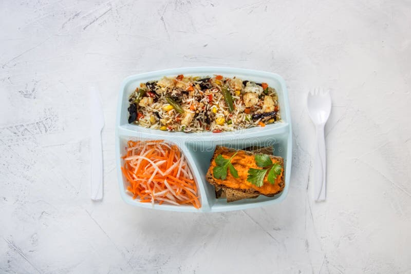 Groene schoollunchbox met rijst, broccoli en wortel dicht bij de witte achtergrond royalty-vrije stock afbeelding Groene schoollunchbox met rijst, broccoli en wortel dicht bij de witte achtergrond royalty-vrije stock afbeelding