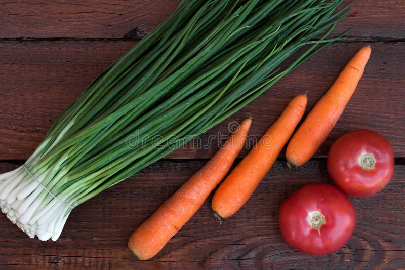 Groene uien, gewassen wortelen, rode tomaten stock fotografie Groene uien, gewassen wortelen, rode tomaten stock fotografie