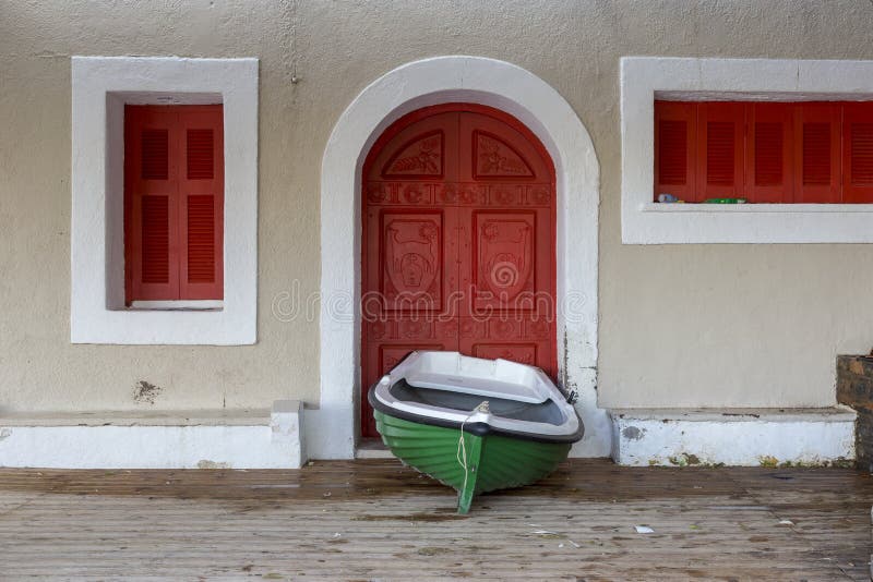Groene vissersboot voor een rode deur in Agios Nikolaos in Kreta Griekenland stock afbeelding Groene vissersboot voor een rode deur in Agios Nikolaos in Kreta Griekenland stock afbeelding