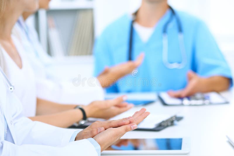 Group of doctors applauding at medical meeting. Close up of physician hands. Teamwork in medicine. Group of doctors applauding at medical meeting. Close up of physician hands. Teamwork in medicine.