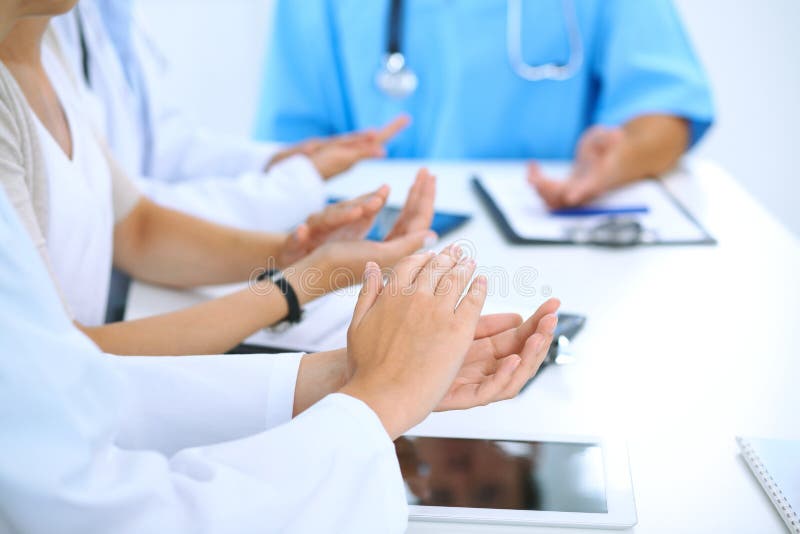 Group of doctors applauding at medical meeting. Close up of physician hands. Teamwork in medicine. Group of doctors applauding at medical meeting. Close up of physician hands. Teamwork in medicine.