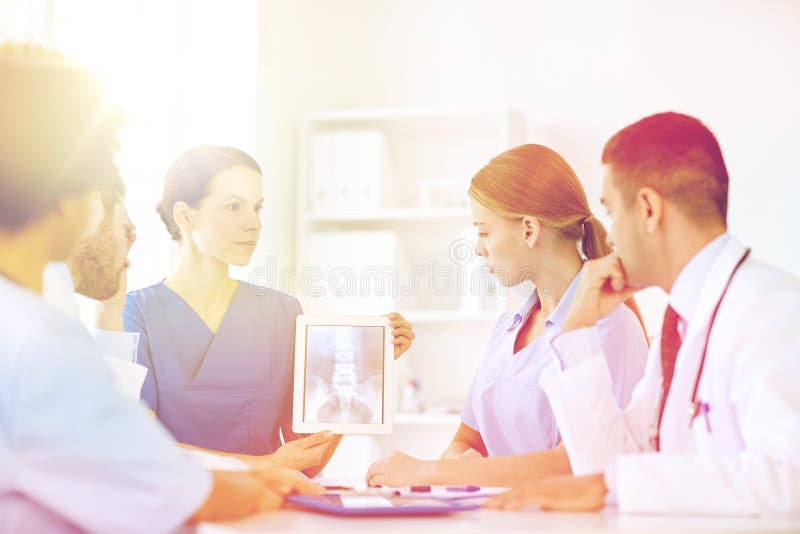Groep artsen met röntgenstraal op tabletpc bij kliniek royalty-vrije stock afbeeldingen Groep artsen met röntgenstraal op tabletpc bij kliniek royalty-vrije stock afbeeldingen