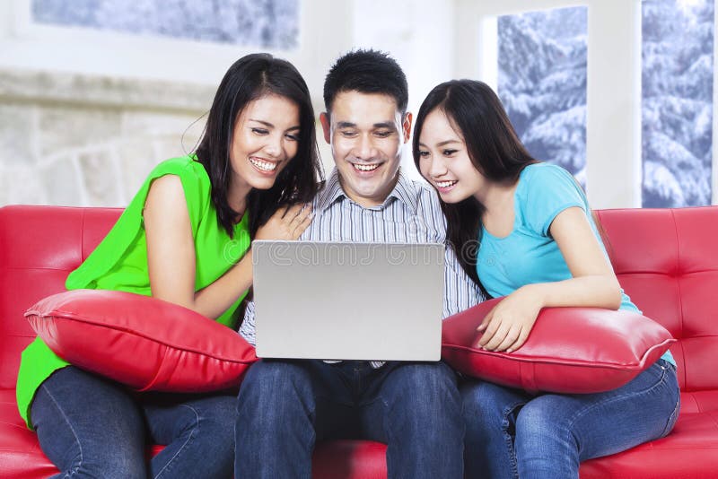 Groep Aziatische mensen die laptop op bank met behulp van royalty-vrije stock fotografie Groep Aziatische mensen die laptop op bank met behulp van royalty-vrije stock fotografie