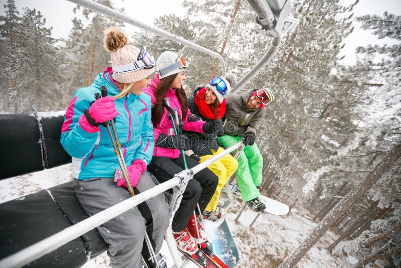Groep de zitting van de vriendenskiër bij de lift van de skistoel in mooie su royalty-vrije stock fotografie Groep de zitting van de vriendenskiër bij de lift van de skistoel in mooie su royalty-vrije stock fotografie
