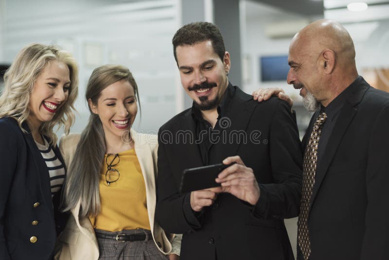 Groep die arbeider telefoon in een baanonderbreking kijken stock foto Groep die arbeider telefoon in een baanonderbreking kijken stock foto