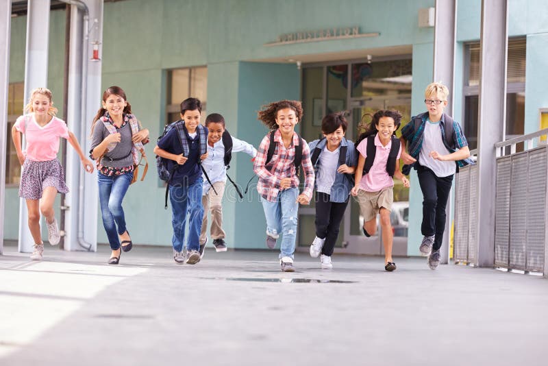 Group of elementary school kids running in a school corridor. Group of elementary school kids running in a school corridor