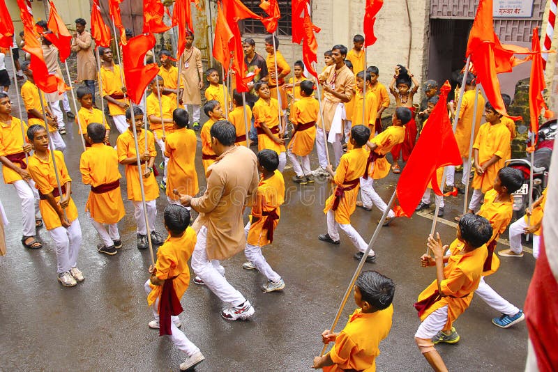 Groep die kleine jongens, met vlaggen, tijdens Ganapti-optocht, Ganapati-festival dansen stock afbeeldingen Groep die kleine jongens, met vlaggen, tijdens Ganapti-optocht, Ganapati-festival dansen stock afbeeldingen