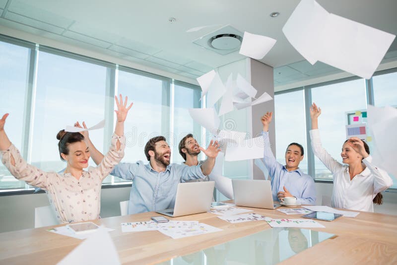 Groep directeuren die door hun handelspapieren in de lucht vieren te werpen stock afbeeldingen Groep directeuren die door hun handelspapieren in de lucht vieren te werpen stock afbeeldingen
