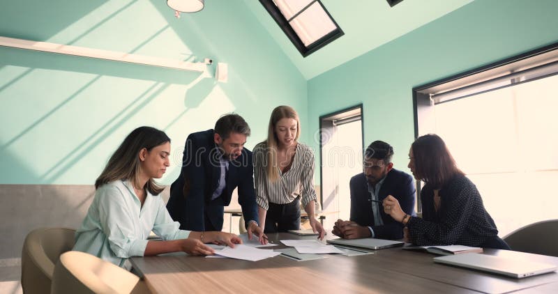 Groep diverse collega ' s maakt financiële analyse met behulp van infografische gegevens