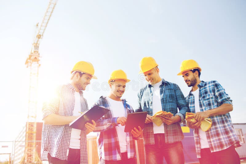 Groep glimlachende bouwers met tabletpc in openlucht royalty-vrije stock afbeeldingen Groep glimlachende bouwers met tabletpc in openlucht royalty-vrije stock afbeeldingen