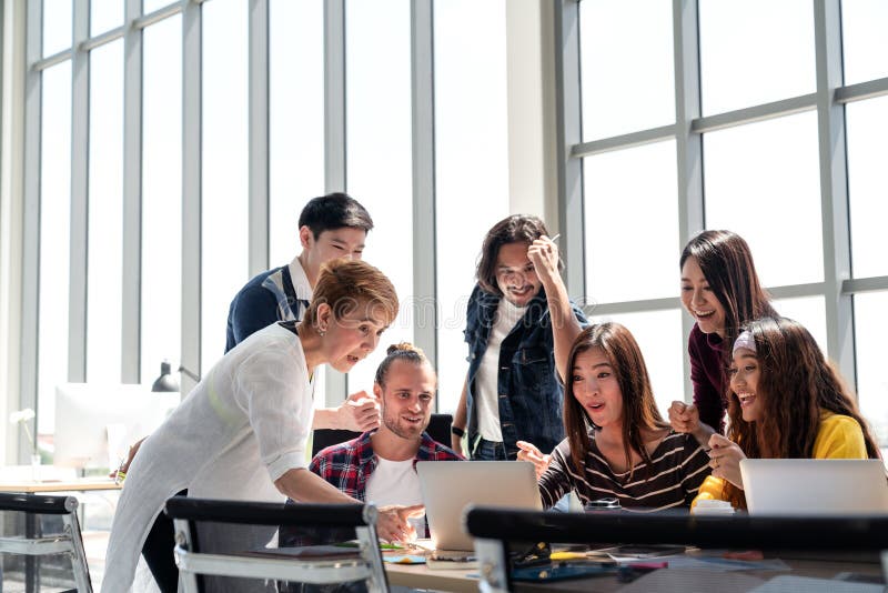 Groep het Team die van Diversiteitsmensen in het succeswerk met laptop op modern kantoor glimlachen en wordt opgewekt