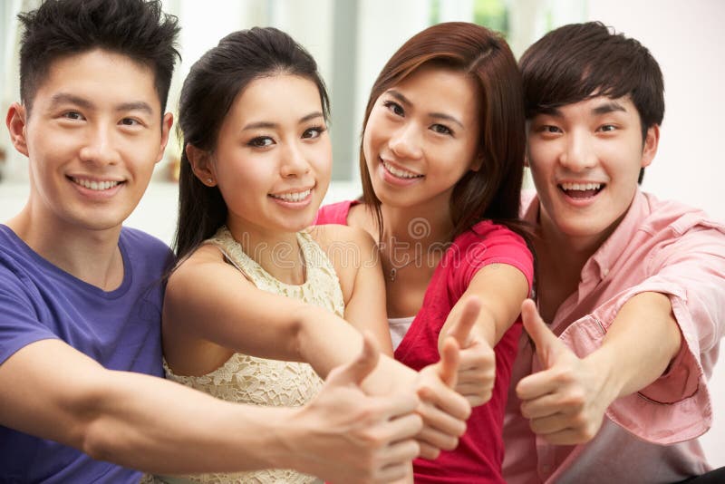 Groep Jonge Chinese Vrienden die thuis ontspannen royalty-vrije stock fotografie Groep Jonge Chinese Vrienden die thuis ontspannen royalty-vrije stock fotografie