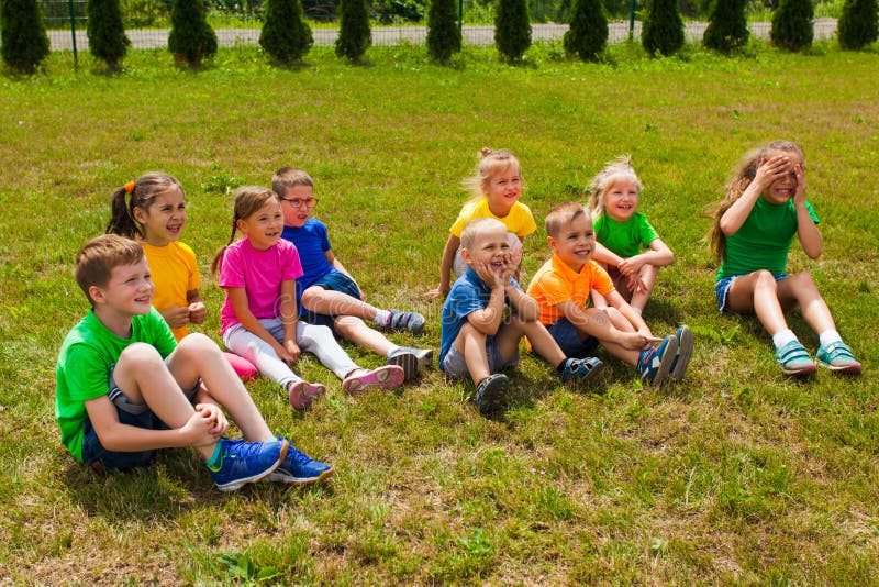 Groep kinderen die samen op het gras zitten royalty-vrije stock foto Groep kinderen die samen op het gras zitten royalty-vrije stock foto