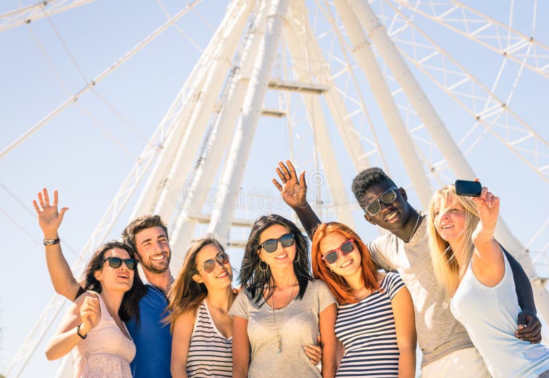 Groep multiraciale gelukkige vrienden die selfie bij ferriswiel nemen royalty-vrije stock foto Groep multiraciale gelukkige vrienden die selfie bij ferriswiel nemen royalty-vrije stock foto