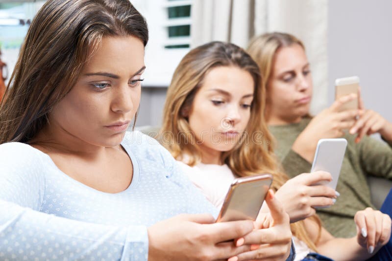 Groep Tieners die Mobiele Telefoons thuis met behulp van stock foto's Groep Tieners die Mobiele Telefoons thuis met behulp van stock foto's