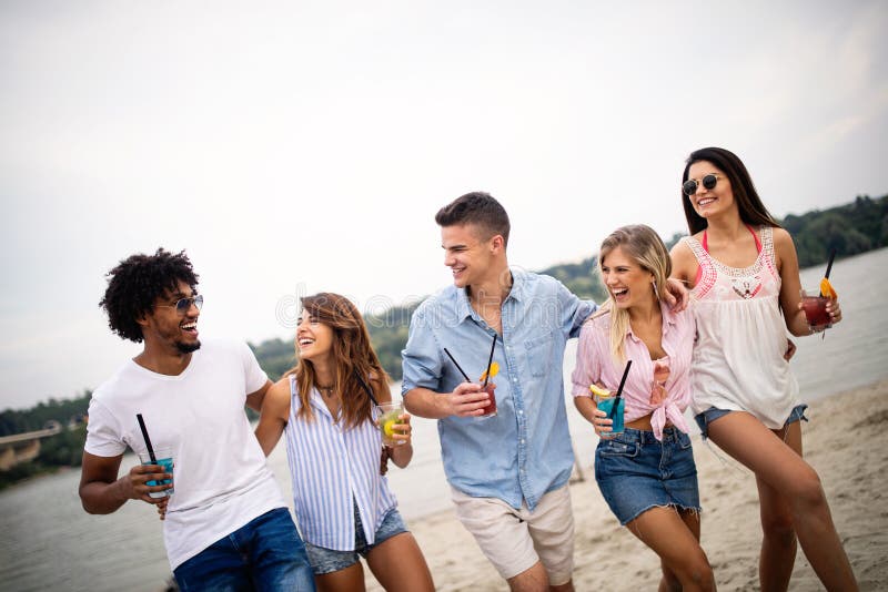 Groep vrienden die pret op het strand hebben de zomervakantie, vakantie en mensenconcept stock afbeeldingen Groep vrienden die pret op het strand hebben de zomervakantie, vakantie en mensenconcept stock afbeeldingen
