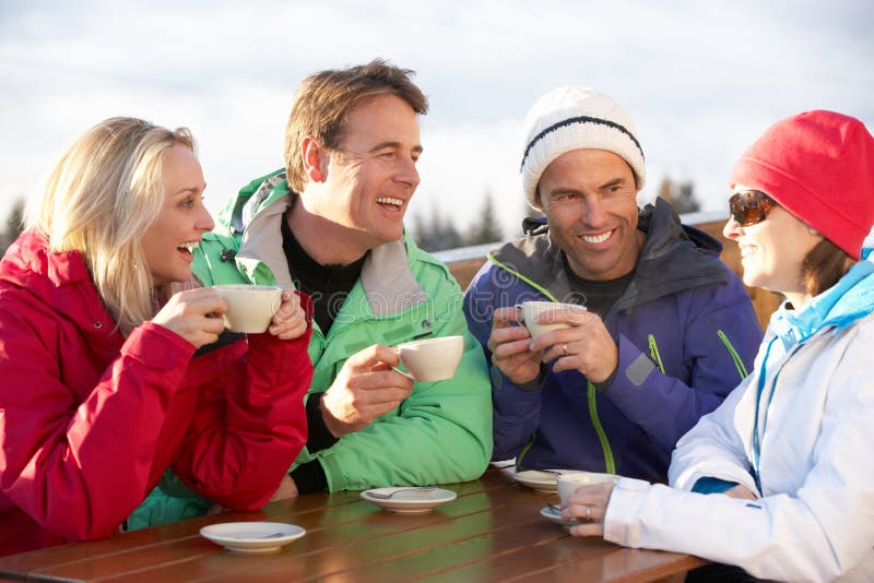 Groep Vrienden die van Hete Drank genieten bij de Toevlucht van de Ski royalty-vrije stock foto's Groep Vrienden die van Hete Drank genieten bij de Toevlucht van de Ski royalty-vrije stock foto's