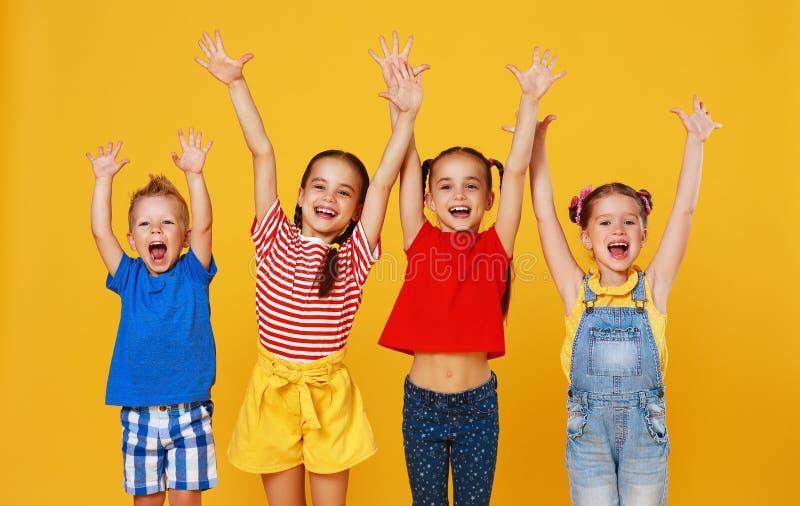 Groep vrolijke gelukkige kinderen op gekleurde gele achtergrond stock afbeeldingen Groep vrolijke gelukkige kinderen op gekleurde gele achtergrond stock afbeeldingen