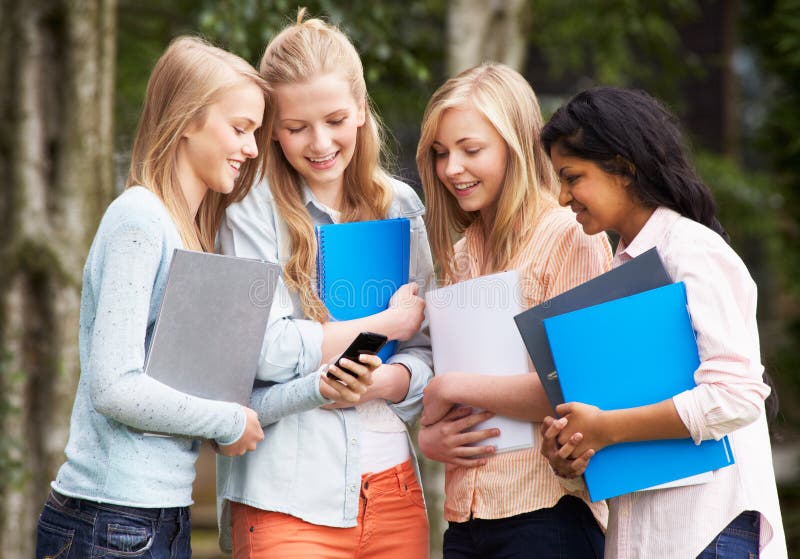 Groep Vrouwelijke Tienerstudenten met Mobiele Telefoon in openlucht stock afbeeldingen Groep Vrouwelijke Tienerstudenten met Mobiele Telefoon in openlucht stock afbeeldingen