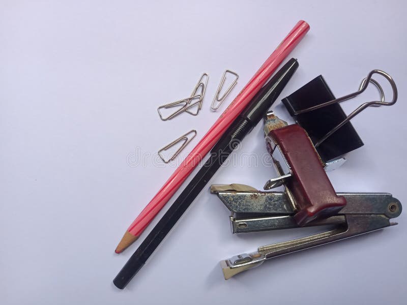 grouping of Stationery containing pencil, ballpoint, paper clip, stapler and staple remover isolated on a plain background. grouping of Stationery containing pencil, ballpoint, paper clip, stapler and staple remover isolated on a plain background