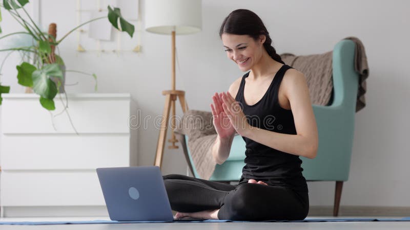 Groet yoga coach online op laptop met glimlach spbi. positieve vrouwelijke 20s