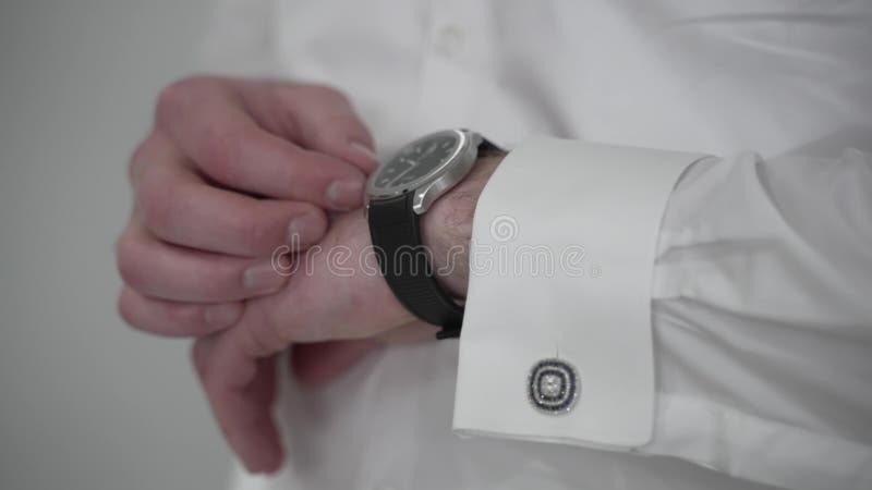 Groom Adjusting Black Square-Faced Watch on White Shirt. Elegant Male Preparing for Wedding Ceremony with Attention to. Detail and Style