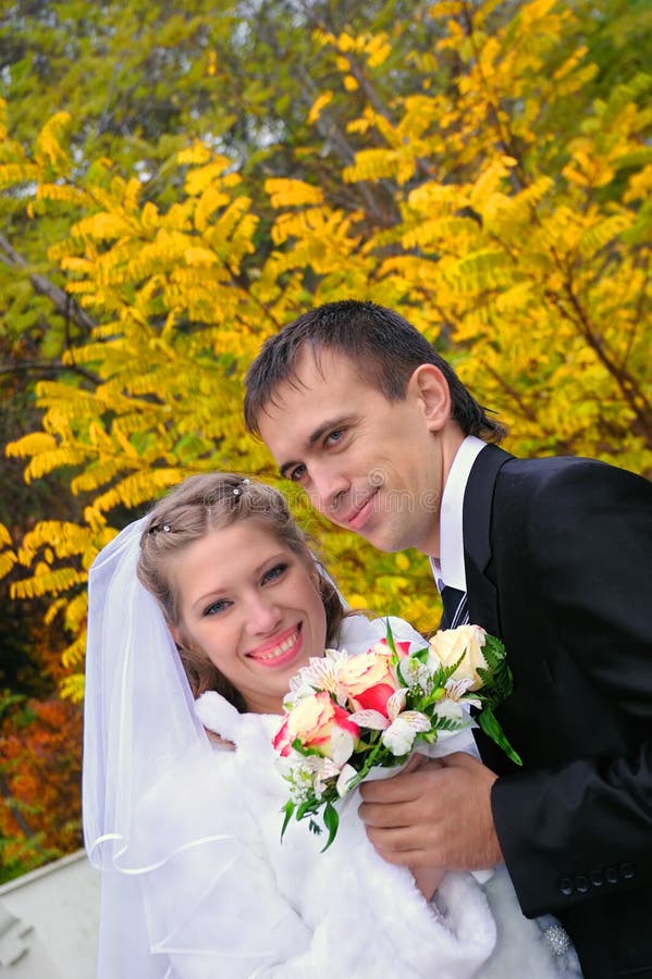 The groom and the bride on an autumn background