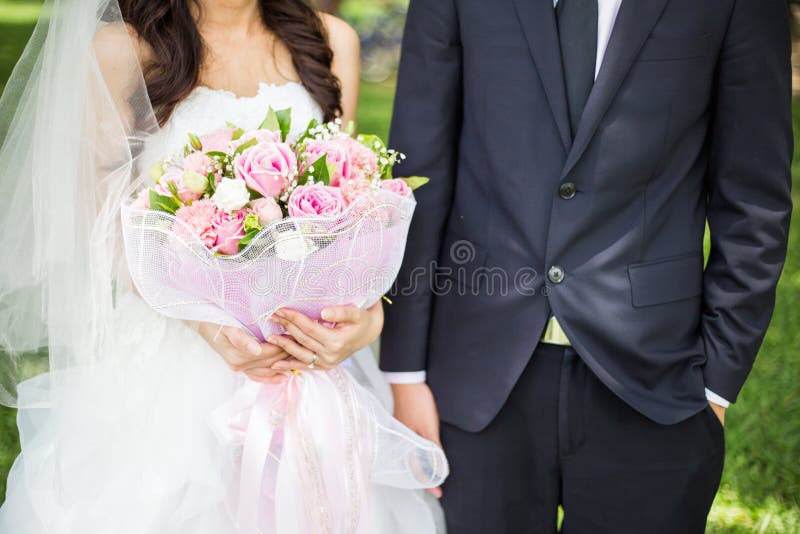 Groom and bride holding flower bouquet. Groom and bride holding flower bouquet