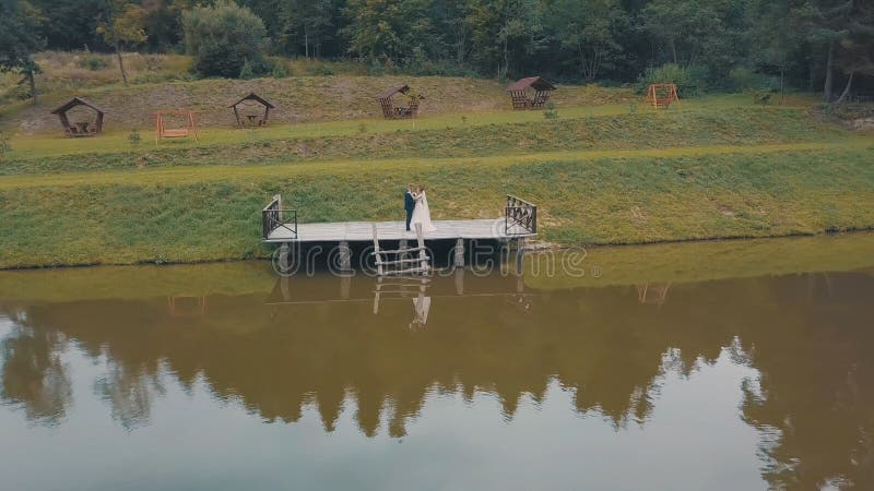 Groom with bride near lake in the park. Wedding couple. Aerial shot royalty free stock photography Groom with bride near lake in the park. Wedding couple. Aerial shot royalty free stock photography