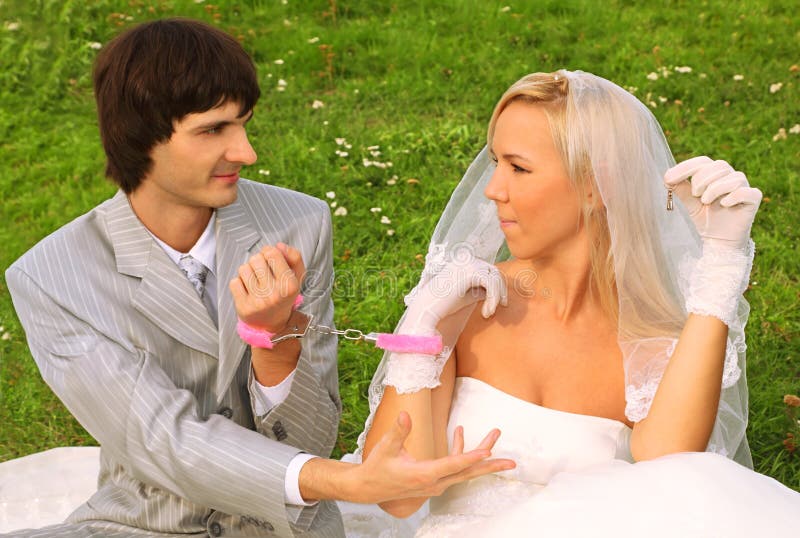 Groom and bride sitting on green grass royalty free stock photos Groom and bride sitting on green grass royalty free stock photos