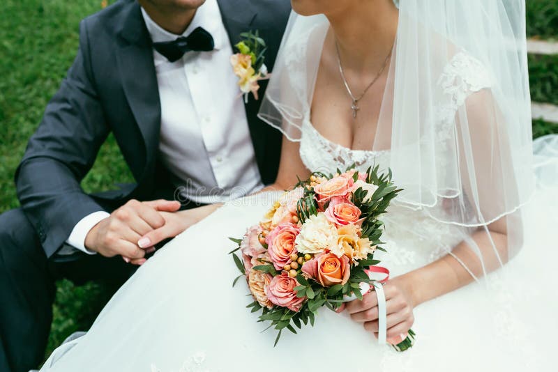 Groom holding a bride hand with weding bouquet on wedding day royalty free stock photo Groom holding a bride hand with weding bouquet on wedding day royalty free stock photo