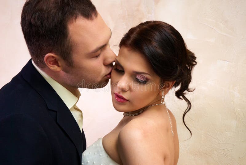 Groom kisses bride in empty room