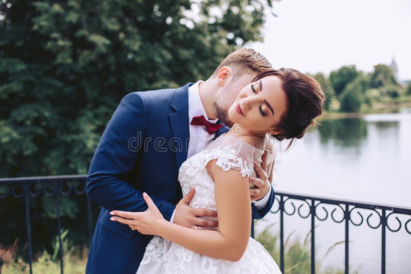The groom kisses the bride on the pier stock images