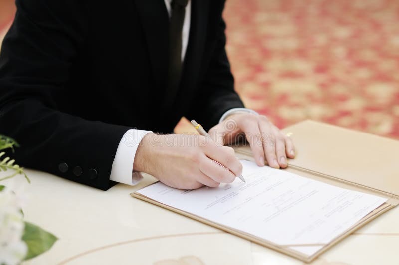 Groom signing marriage license or wedding contract royalty free stock photos Groom signing marriage license or wedding contract royalty free stock photos