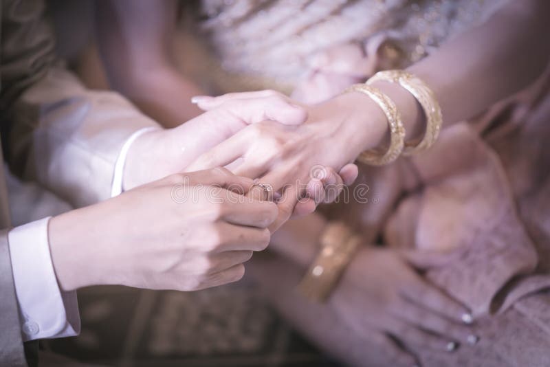 Bride Slipping Ring on Finger of Groom at Wedding Stock Photo Image