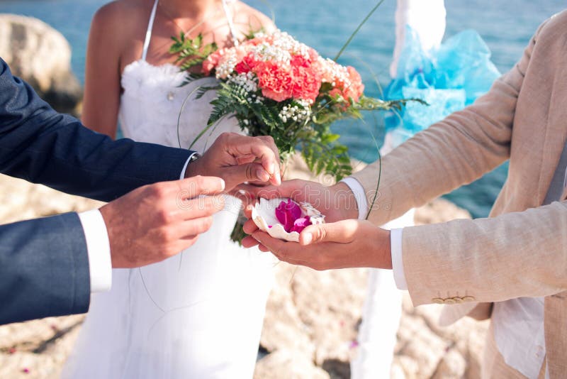 The groom takes the ring. wedding in cyprus, bride and groom on a stone bridge in Agia Napa. arch and table for