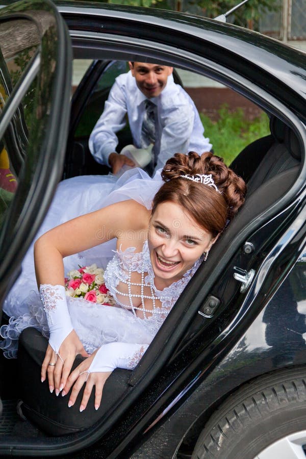 Groom trying to drag the bride out of the car