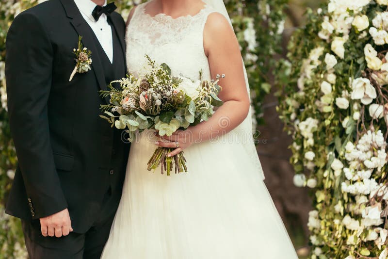 Groom в черном костюме и невеста в белом платье свадьбы с деревенским стоковая фотография rf
