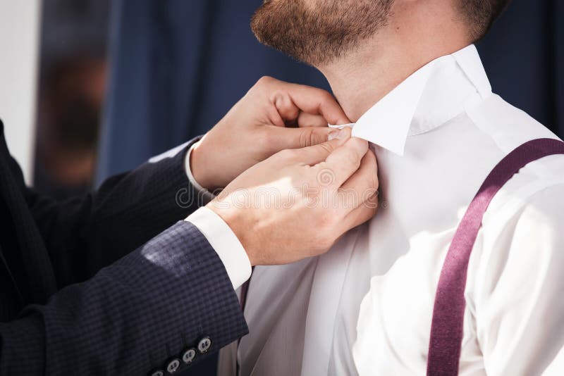 Groomsman aide à se toiletter pour mettre dessus la chemise images stock Groomsman aide à se toiletter pour mettre dessus la chemise images stock