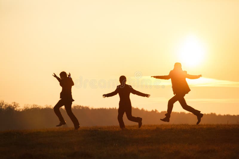 Groomsmen playing fool in the rays of sunset somewhere on the field stock photography