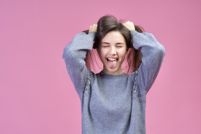 Groot gedetailleerd Studioportret op roze jong Kaukasisch meisje als achtergrond in een grijze sweater, gesloten ogen stock foto Groot gedetailleerd Studioportret op roze jong Kaukasisch meisje als achtergrond in een grijze sweater, gesloten ogen stock foto