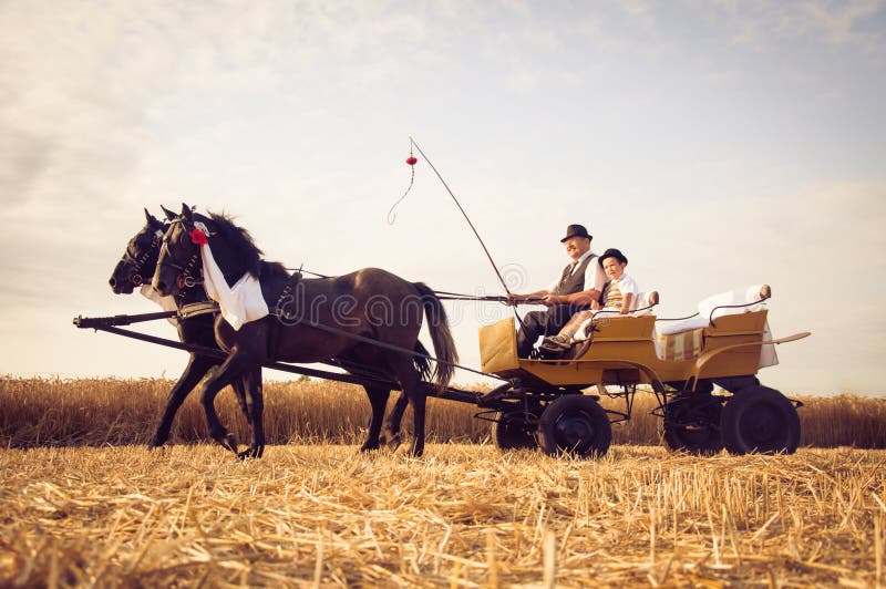 Grootvader en kleinzoon het rideing in vervoer die traditioneel kostuum in Vojvodina, Servië dragen stock foto's Grootvader en kleinzoon het rideing in vervoer die traditioneel kostuum in Vojvodina, Servië dragen stock foto's