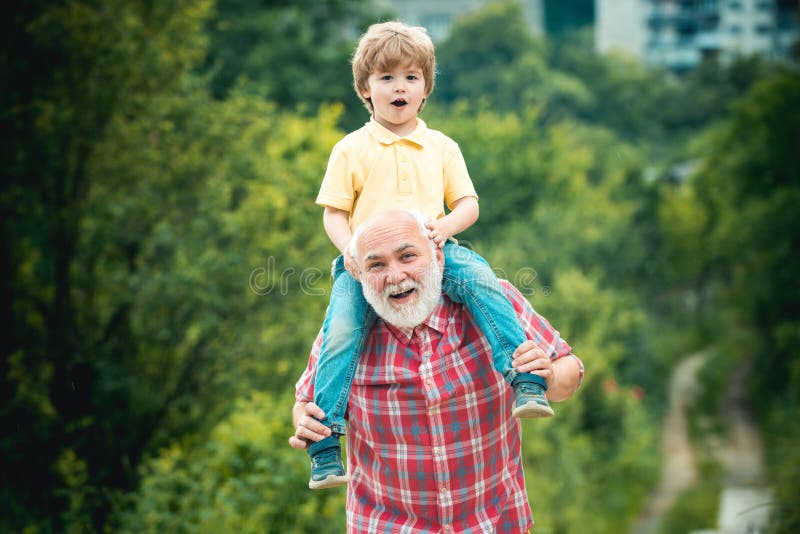 Grootvader en kleinzoon openlucht genieten van En papa en jongen die glimlachen koesteren Grootvader en kleinzoon in het park