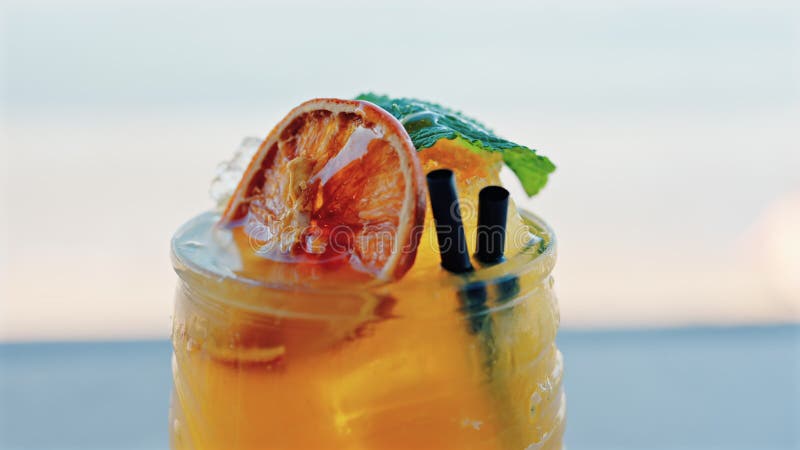 Gros plan d'un cocktail orange sur une tablette banque de vidéos