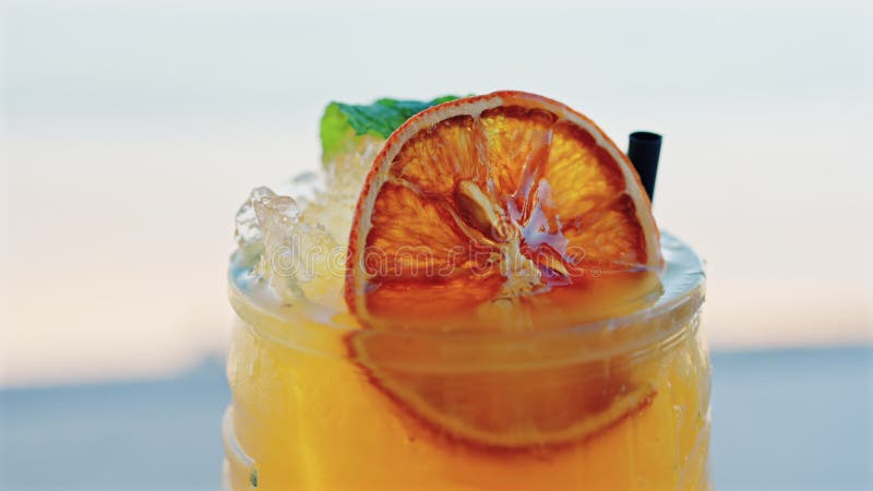 Gros plan d'un cocktail orange sur une tablette banque de vidéos