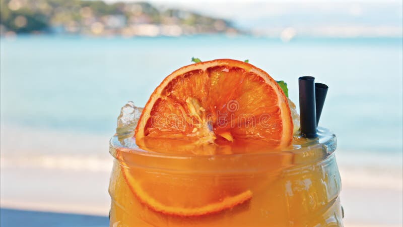Gros plan d'un cocktail orange sur une tablette clips vidéos